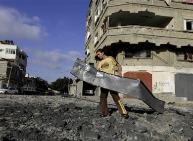 A Palestinian man carries rubble near a Hamas training camp following an Israeli air strike on it early morning in Gaza City.