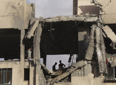 Palestinian youths inspect a damaged building after it was hit by an Israeli airstrike in Beit Lahiya, northern Gaza Strip.
