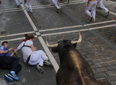 Two people fall during the running of the bulls yesterday