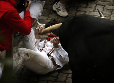 Bill Hillman struggles with a bull after being gored at the San Fermin festival in Pamplona.