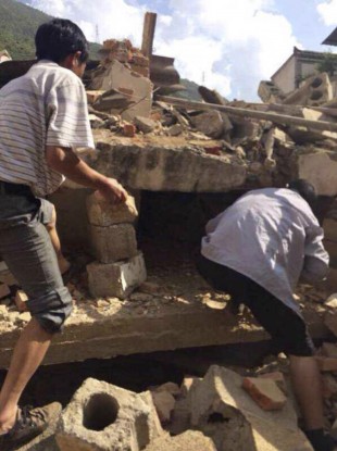 In this photo taken by cellphone and released by China's Xinhua News Agency, men at rubbles of buildings look for survivors after an earthquake in Ludian County of Zhaotong City.