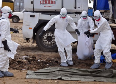 Health workers carry the body of a man found in the street, suspected of dying from the ebola virus, in the capital city of Monrovia, Liberia.