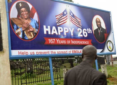 A billboard reading 'Help us prevent the spread of Ebola, center, with the face of Liberia President Ellen Johnson Sirleaf, left, in the city of Monrovia, Liberia.