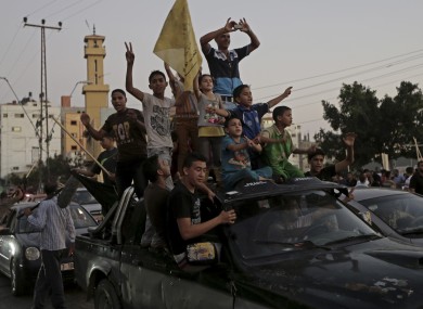 Palestinians celebrate the cease-fire between Palestinians and Israelis at the main road in Gaza.