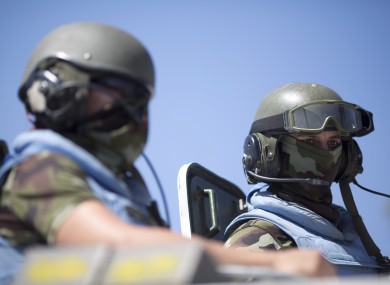Two UN peacekeepers sit on top of an armored vehicles from the U.N.