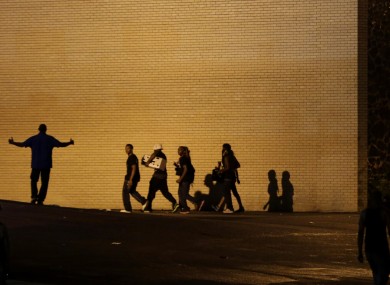 People walk away from a shop after it was looted.