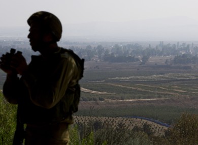 An Israeli soldier observes Syria's Quneitra province at an observation point in the Israeli-controlled Golan Heights.