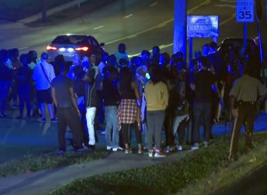 Crowd gathers near the scene where a police officer was shot.