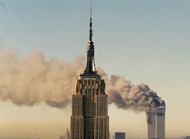 The twin towers of the World Trade Center burn behind the Empire State Building in New York.