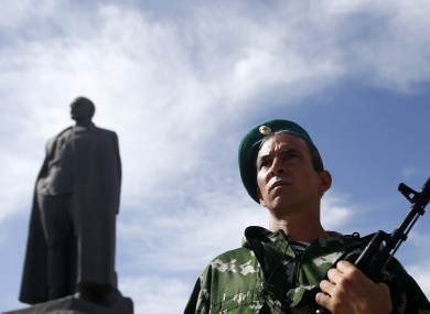 A pro-Russian gunman guards a monument to Soviet security police founder Felix Dzerzhinsky in the town of Luhansk.