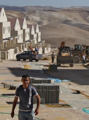 A Palestinian worker walks at a construction site in the West Bank Jewish settlement of Maaleh Adumim, near Jerusalem in 2009.