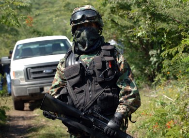 A Mexican navy marine guards the road that leads to the grave site.