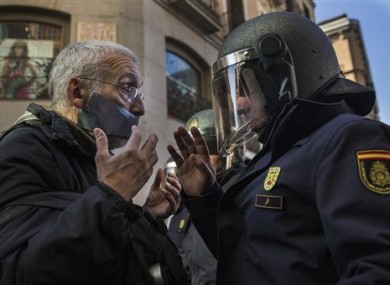 A policeman communicates with a demonstrator by a cordoned off street, during a protest against Spanish Citizens Security Law in Madrid.