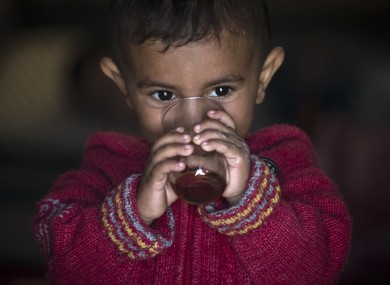 A Syrian Kurdish refugee child from the Kobani area, drinks tea at a camp in Suruc
