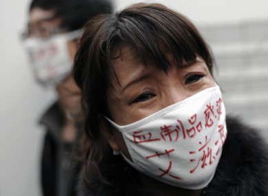 File photo: A woman whose son was infected with HIV, wearing a face mask baring the words
