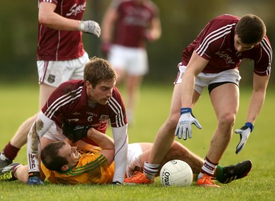 Fergal Clancy is tackled by Gary O'Donnell and Shane Walsh.