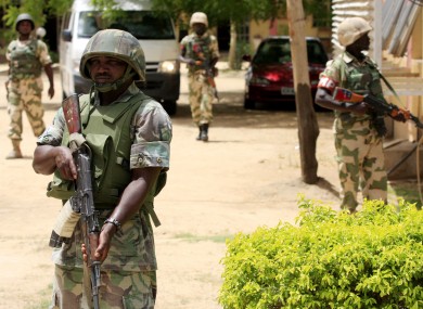 Nigerian soldiers stand guard at the offices of the state-run Nigerian Television Authority in Maiduguri.