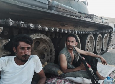 Members of a militia group loyal to Yemen's President Abed Rabbo Mansour Hadi, known as the Popular Committees, chew qat as they sit next to their tank, guarding a major intersection in Aden.