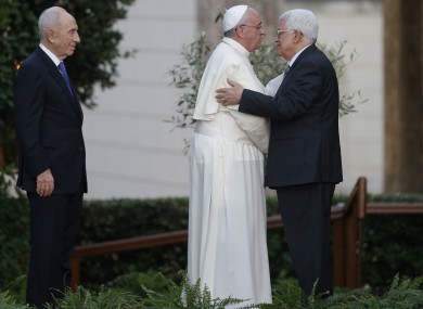 Pope Francis and Palestinian President Mahmoud Abbas embrace each other.