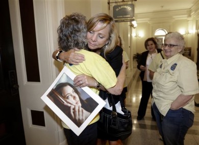 Debbie Ziegler holds a photo of her daughter, Brittany Maynard, as she receives congratulations from Ellen Pontac, after a right-to die measure was approved by the Assembly in Sacramento, California