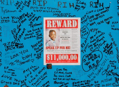A reward sign and messages hang near where Tyshawn Lee was fatally shot in Chicago.