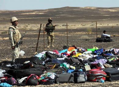 Egyptian Army soldiers stand near luggage and personal effects at the crash site.