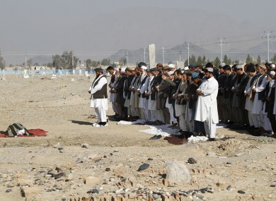Afghan men pray for Mohammad Sami, a young man killed during clashes at the airport.
