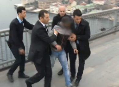The man is escorted away from the bridge by the president's staff.