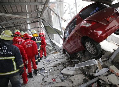 Rescue workers search a collapsed building from an early morning earthquake in Tainan, Taiwan.