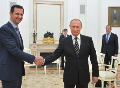 In this file photo taken on Tuesday, Oct. 20, 2015, Russian President Vladimir Putin, center, shakes hand with Syrian President Bashar Assad as Russian Foreign Minister Sergey Lavrov, right, looks on