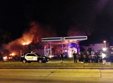 Authorities respond near a burning gas station as dozens of people protest following the fatal shooting of a man in Milwaukee