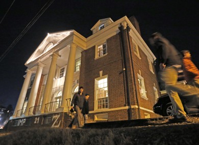 Students walk by the Phi Kappa Psi house at the University of Virginia.