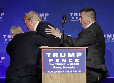 Members of the Secret Service rush Republican presidential candidate Donald Trump off the stage at a campaign rally in Reno, Nevada yesterday.