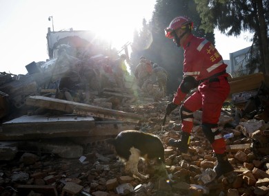 File photo of an army officer searching through the rubble of a building that collapsed in China's Yunnan last week as part of a drill.