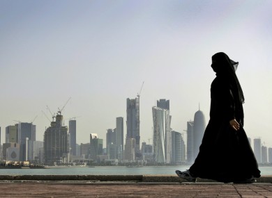 In this May 14, 2010 file photo, a Qatari woman walks in front of the city skyline in Doha, Qatar.