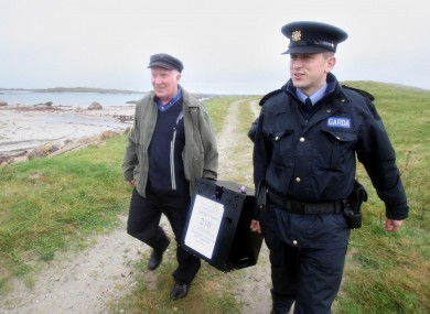 Electoral officer, Hugh O'Donnell with Garda Brendan McCann, carry the ballot box, for the Lisbon Treaty voting, on Inishfree Island off the coast of Co Donegal.