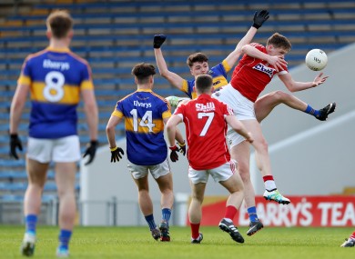 Tipp's Conall Kennedy competes for possession with Cork's Jack Murphy .