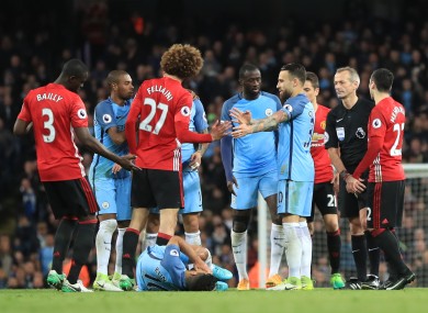 Aguero lies on the ground as Fellaini is shown red.