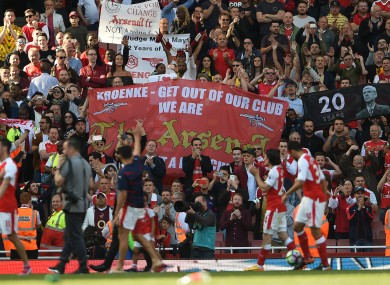 Arsenal fans hold various banners as the players complete a lap of appreciation.