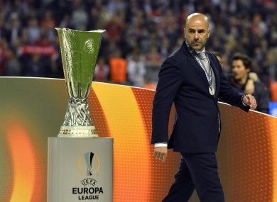 Ajax coach Peter Bosz walks past the trophy at the end of the Europa League final.