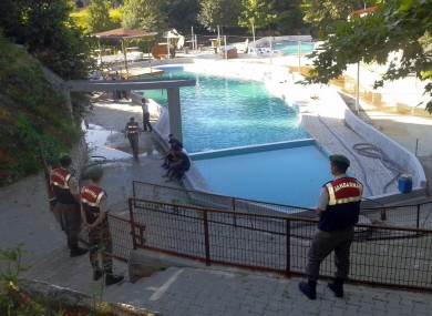 Paramilitary police officers investigate after five people were caught up in an electrical current in the pool at the park in the town of Akyazi, in Sakarya province, western Turkey.