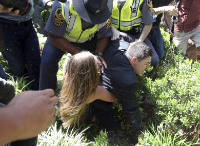 A woman tackles Jason Kessler to the ground following the press conference