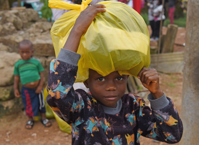 A boy gets free clothes at the Saio Elementary Community School after the mudslides in Freetown