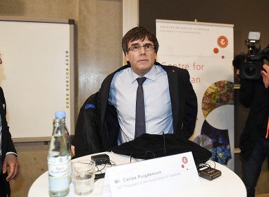 Carles Puigdemont takes off his coat as he prepares to take part in the debate at the University of Copenhagen.