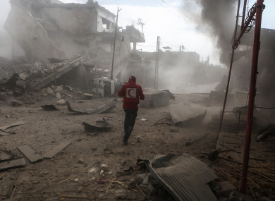 A Syrian Red Crescent volunteer inspects a site that was targeted by rockets fired by warplanes of the Syrian government in the rebel-held town of Douma, Eastern Ghouta.