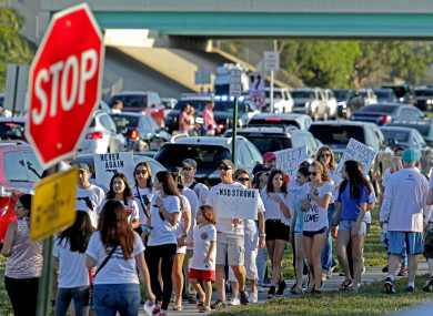 A large group of people demonstrating outside the school at the weekend