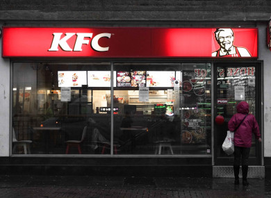 A women reads a closed sign in a KFC restuarant window in London.