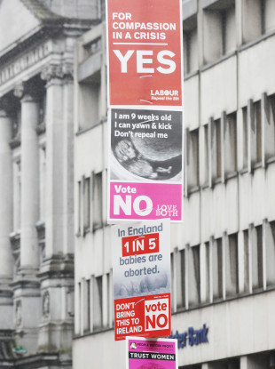 Posters from both sides on a pole at Dublin's College Green.