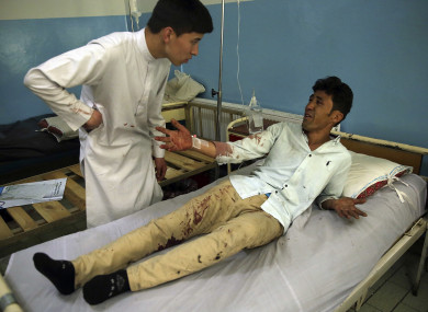 A wounded man, who lost two his daughters, lies on a bed in a hospital after the deadly suicide attack