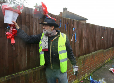 Iain Gordon pulls the flowers down from a fence opposite the house of Richard Osborn-Brooks in South Park Crescent in Hither Green, London.